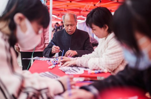 风筝非遗传承人杨付涛老先生与游客一起做风筝