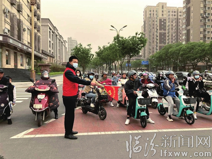 志愿者在十字路口进行交通劝导 翟世豪 摄