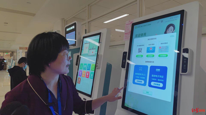 ▲华西医院门诊部护士长刘芯如演示如何使用人脸识别进行自助缴费