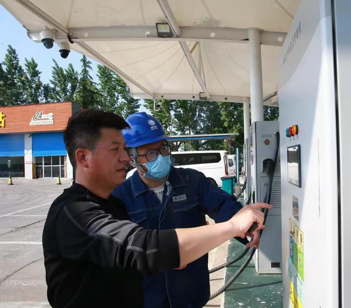 "五一"期间 ，国网焦作供电公司工作人员指导车主使用充电桩