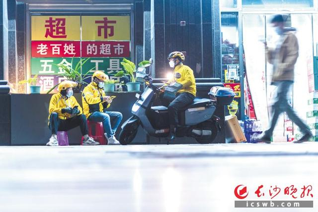 因夜间订单多，骑手们深夜都喜欢在秋香超市门口等单。 谭亮 摄