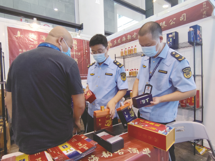     执法人员在展会现场取证（资料图片） 本报记者 苏昭宇 摄