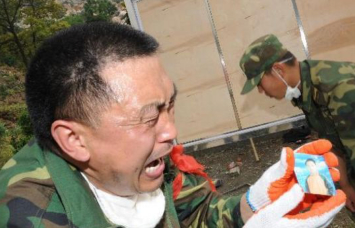 △2008年5月15日，北川县城的救援人员发现了一张照片，忍不住痛哭。