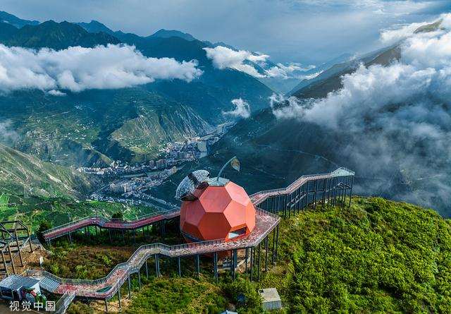 2022年7月27日，四川阿坝，雨后的汶川县城上空和爬墙大熊猫揽城云雾缭绕，“仙气”十足。来源：视觉中国