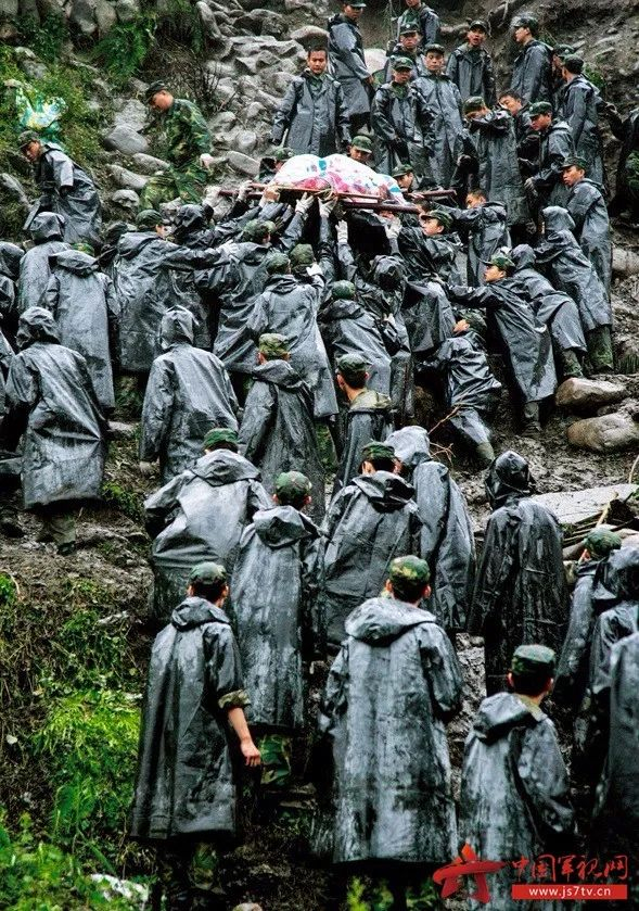 △山体垮塌，乱石滚成了陡坡，泥泞难行，在转移被困人员时，救援官兵用身体搭起人梯，把生命高高举过头顶。