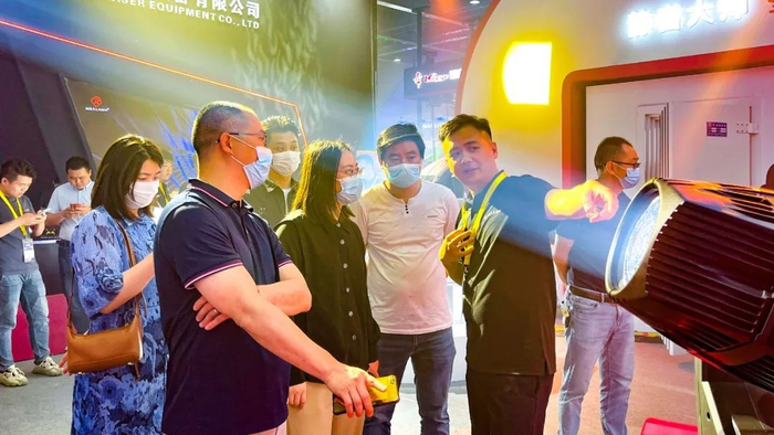 （展位现场，众多客户驻足观看明道灯具性能）