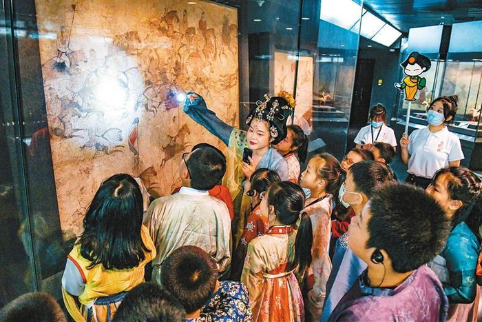 小朋友在陕历博唐代壁画珍品馆中了解唐墓壁画保护与修复工作 （资料图片）