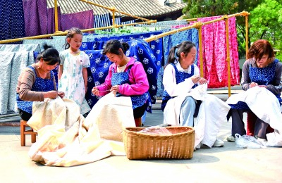     云南巍山县，几位民族工艺厂女员工在进行非遗扎染产品制作。张树禄摄/光明图片
