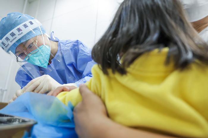 5月9日22时许，北京协和医院急诊科发热门诊护士姜迪为一个儿童采指血。新华社记者 张玉薇 摄