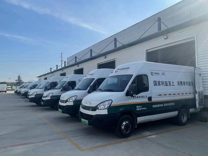 图为启用新能源汽车进行卷烟配送