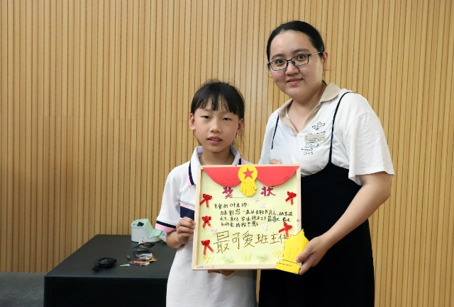 在活动现场，三年级（2）班学生为班主任颁发自己制作的“奖状”。熊杰 摄