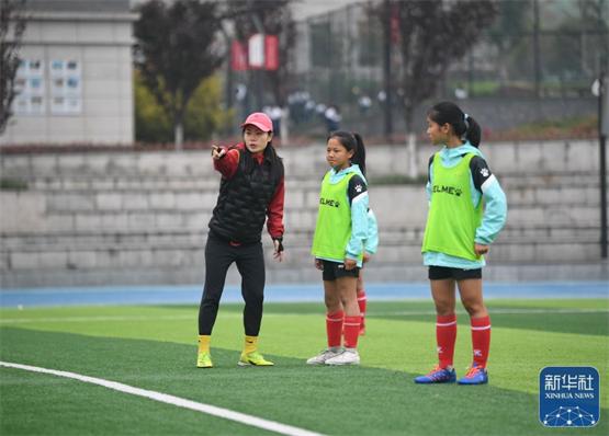 3月28日，在泸州天立春雨学校足球场，教练陈博君在指导队员吉联么李雪(中)。