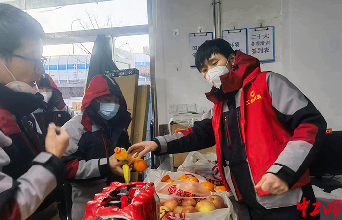 高峰期，张亚威为快递小哥分发水果饮料。受访者供图