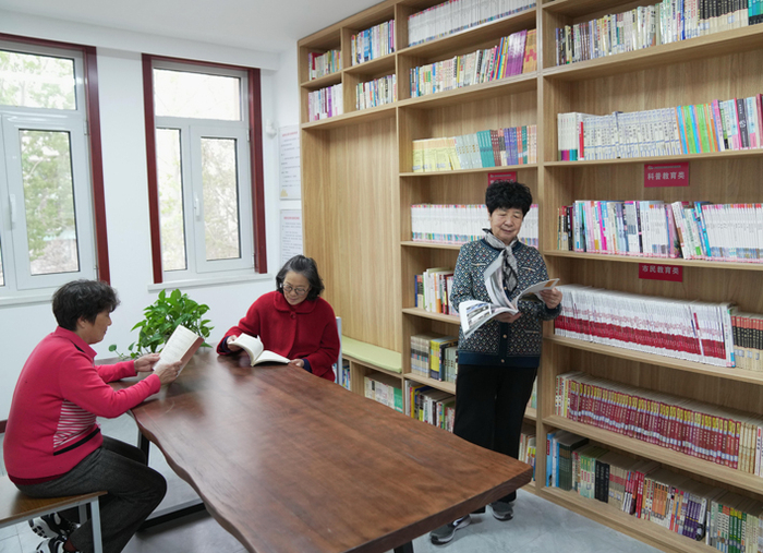 今年退休人员基本养老金再次上调。图为三位老人在秦皇岛市北戴河区安居社区日间照料服务中心图书室翻阅图书&nbsp;新华社图
