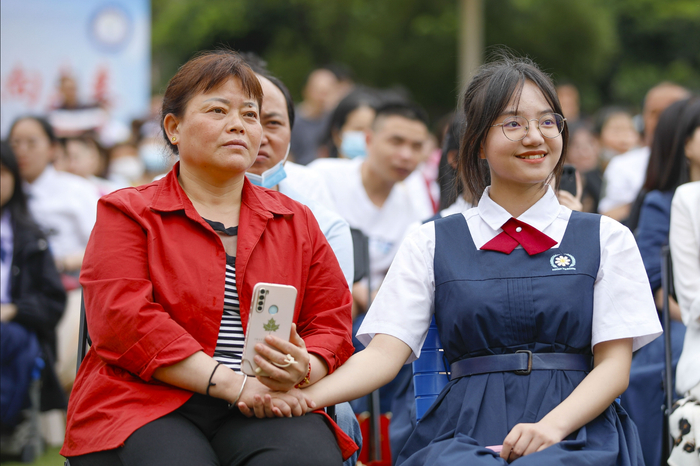 高三学生成人礼，一位妈妈握着学生的手。通讯员 谢贵明 摄