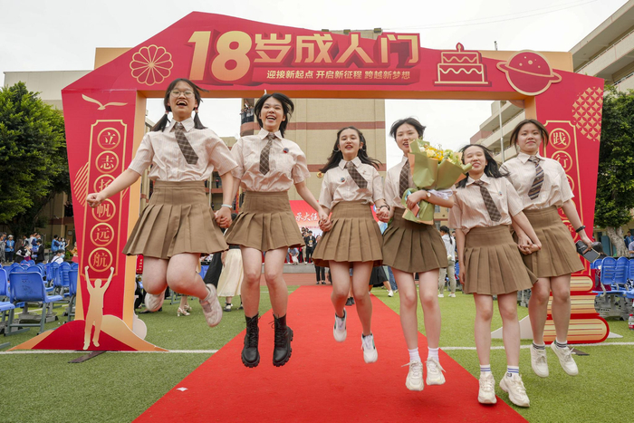 高三学生成人礼，学生一起携手在成人门前跳跃。通讯员 谢贵明 摄