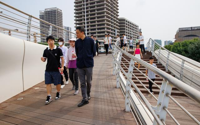 同学们在桥上边走边和教授交流心中困惑。 新京报记者王子诚 摄