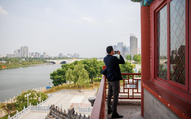 课前，王国彬在“大光楼”上拍照，左侧远处就是他设计的桥。 新京报记者王子诚 摄