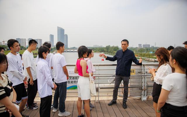 5月24日，“千荷泻露桥”的设计者在桥上给学生们授课。 新京报记者王子诚 摄