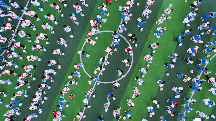 拿到亚运会公仔的小朋友们开心地挥手