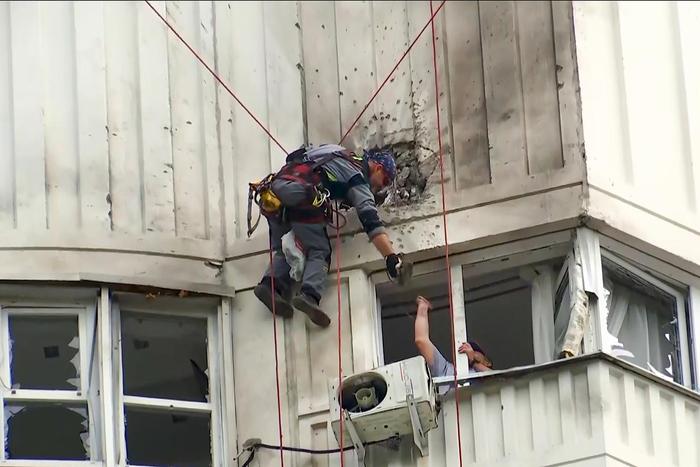 （视频截图）当地时间5月30日，俄罗斯莫斯科，乌克兰无人机袭击后，调查人员检查受损公寓楼。图据视觉中国