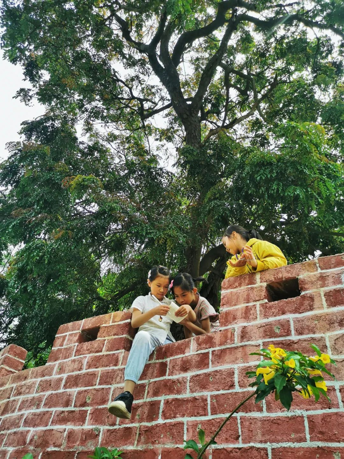 2023年4月10日，佛冈县石角镇黄花车一村，小学生在村里的百年格木树休闲风景区做作业。（清远日报签约摄影师 黄国英 摄）