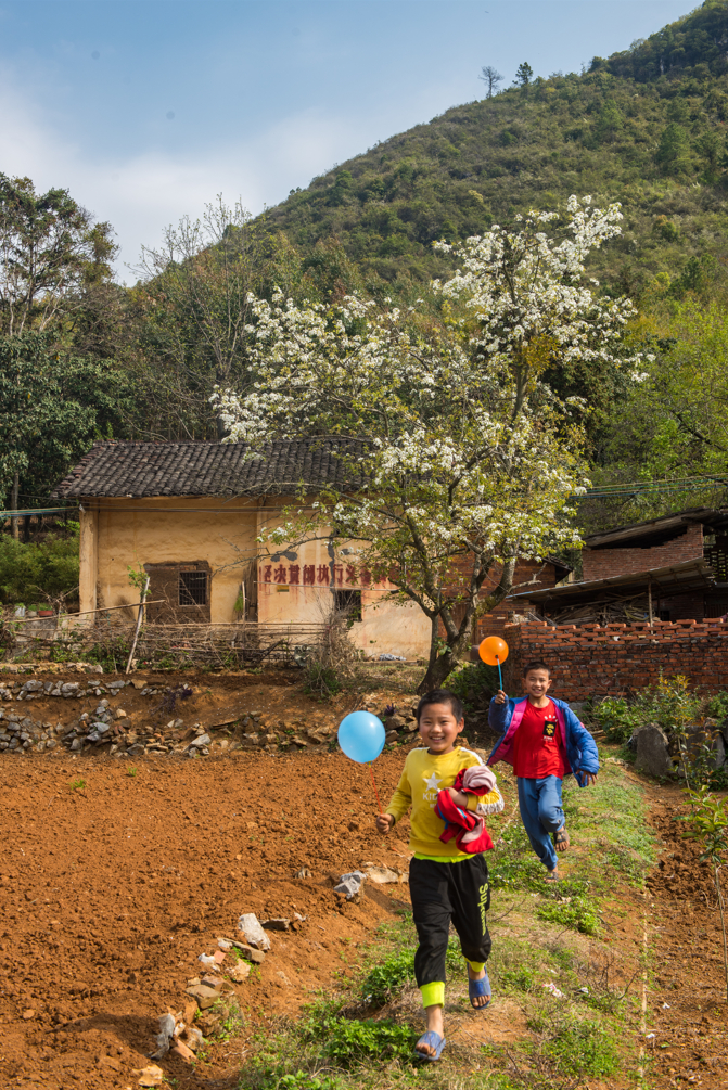 2022年3月13日上午，连南瑶族自治县三排镇干路村，两名小学生在村中小道追逐嬉戏。  清远日报签约摄影师  黄慧诚  摄