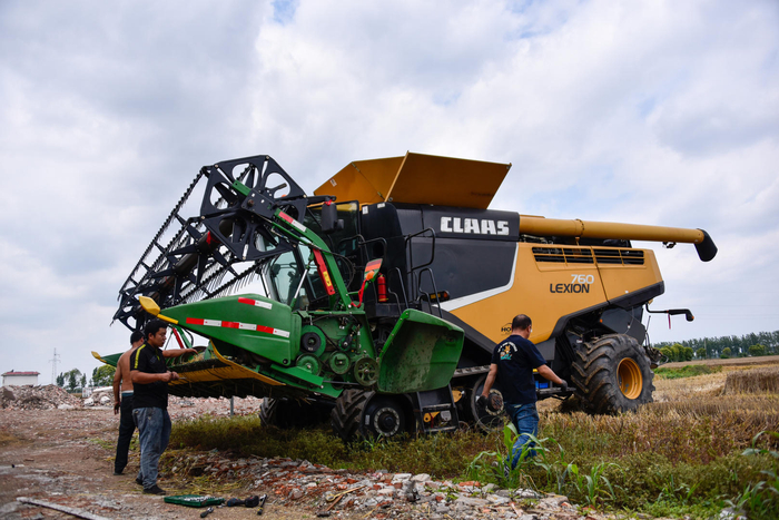 ↑5月30日，河南南阳，收割机准备在农田里收割小麦。图据视觉中国