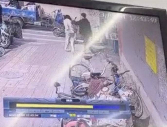 ↑监护人从附近商家的监控发现，一名男生在后方用手推着少女肩膀往马路上走