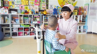 保健护士在给孩子测量坐高。受访者供图