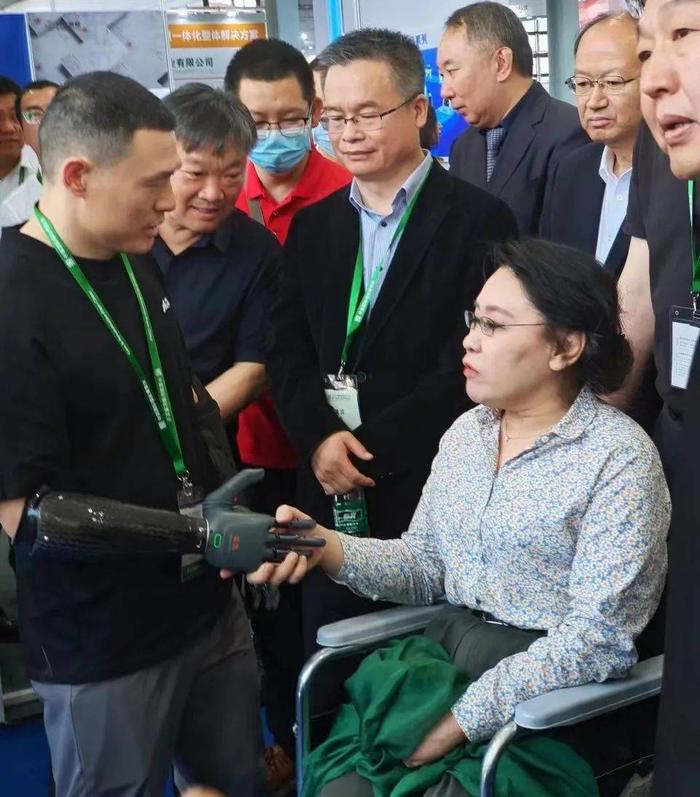 中国残联第七届主席张海迪与BrainCo强脑科技产品体验官倪敏成握手