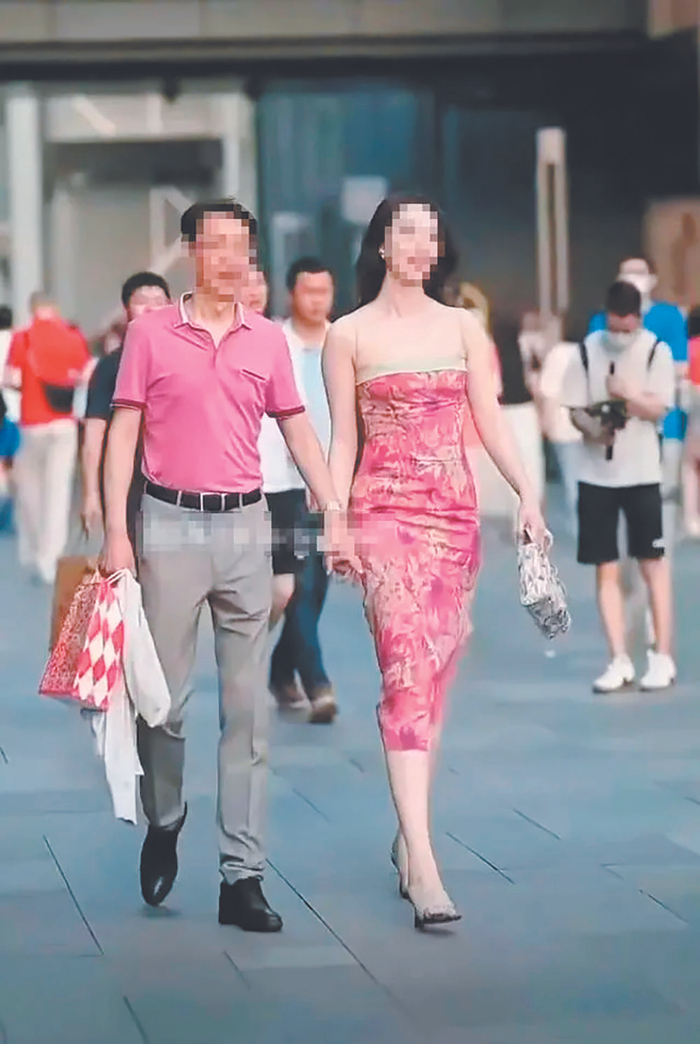     一名街拍摄影师拍到一中年男子与年轻女子牵手逛街，举止亲密，后将视频发至网上，引发网友关注。