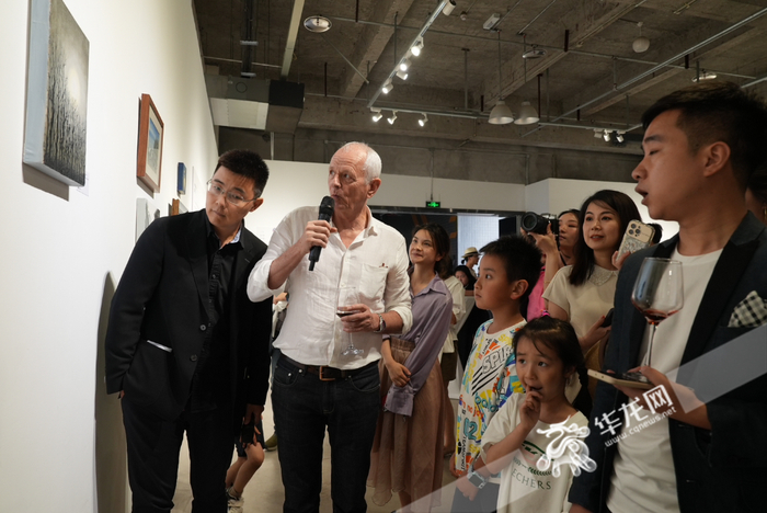 英国驻重庆总领事史云森（左二）正在给大家介绍他的作品。华龙网-新重庆客户端 首席记者 王玮 摄