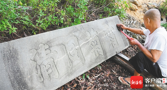 6月12日，海口市美兰区灵山镇潭堀村，村民在擦拭“节孝”石碑的背面，上面刻着“霜菊同清”。记者 张茂 摄