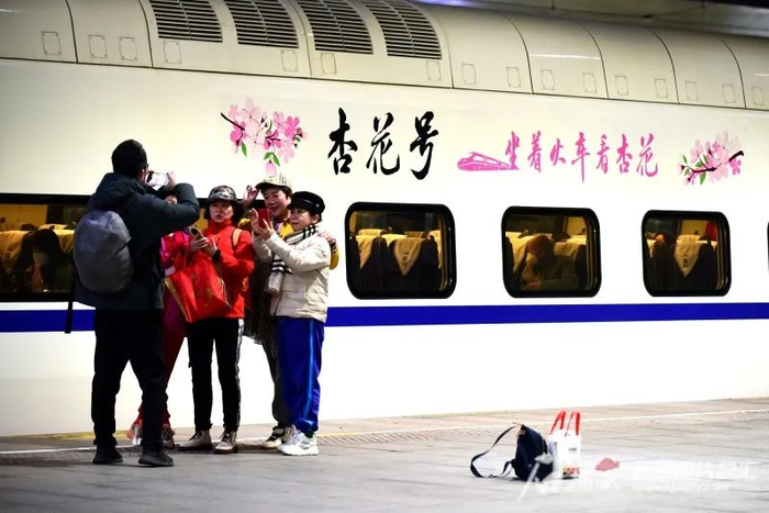 乘坐“杏花号”高铁列车的旅客拍照留念（资料图片）。吴奇摄