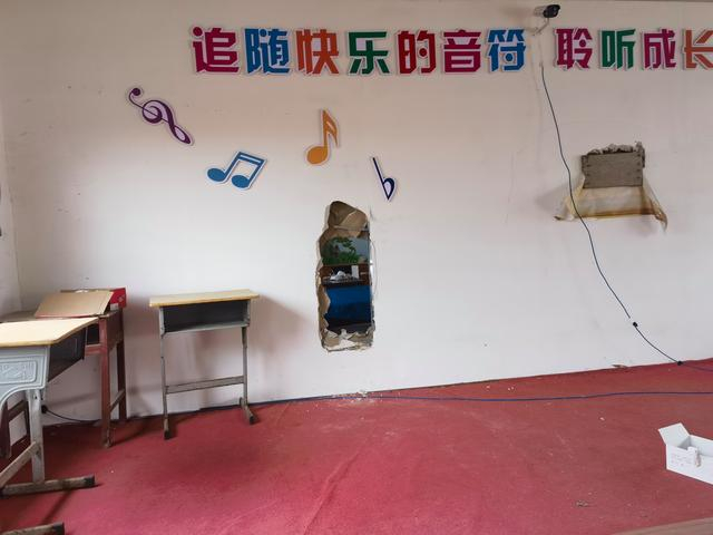 事发后，音乐教室和校长办公室间隔的这堵墙不知道被谁凿开了一个洞。新京报记者 李照摄