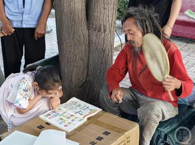 ▲刘彦弘正在给小学三年级学生辅导英语。 摄影/上游新闻记者 张锦