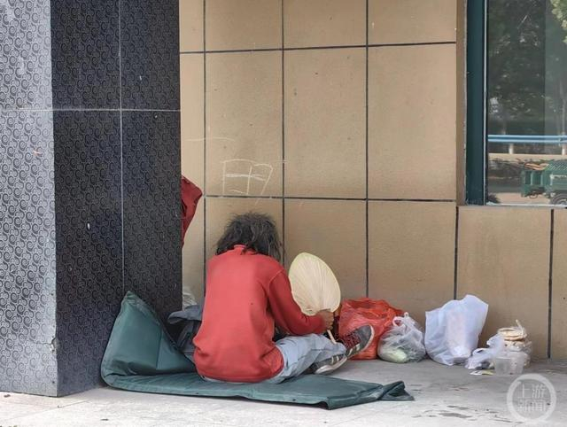 ▲刘彦弘背对着主播休息，身旁堆放着行李和主播送的食物。摄影/上游新闻记者 张锦