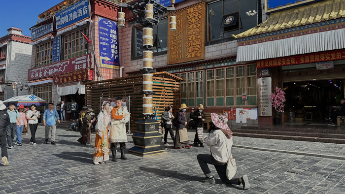 拉萨八廓街上，游客在拍摄藏服写真。中新网记者朱延静摄