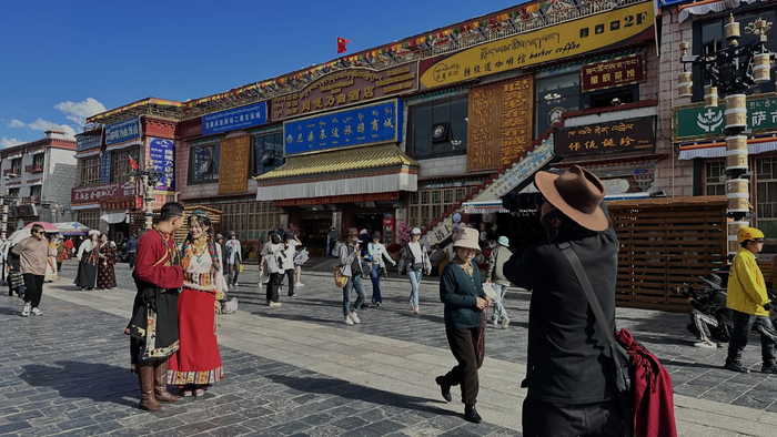 拉萨八廓街上，游客在拍摄藏服写真。中新网记者朱延静摄