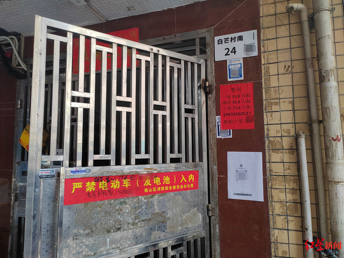 ↑白芒村内的自建房，搬家公司和售房公司在门禁大门上张贴了搬家售房信息