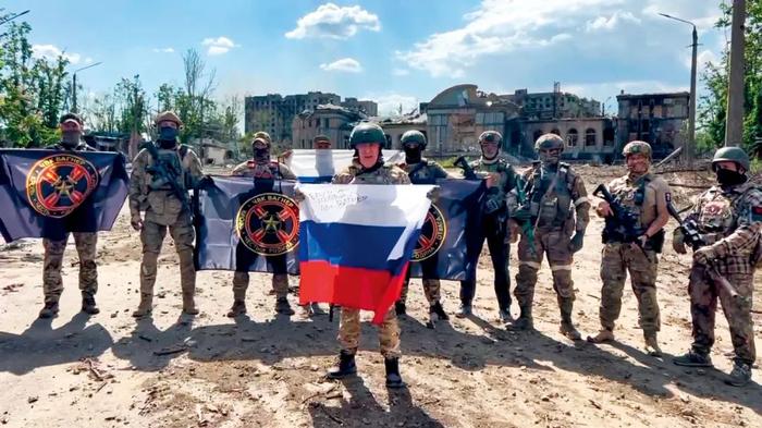 2023年5月20日，顿涅茨克地区巴赫穆特，普里戈任手持俄罗斯国旗在瓦格纳组织士兵面前说话。