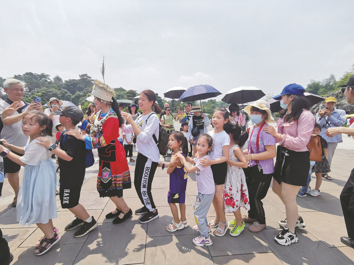     暑期出游热情高涨，不少家长带着孩子出门游玩（资料图）   本报记者赖有光 摄