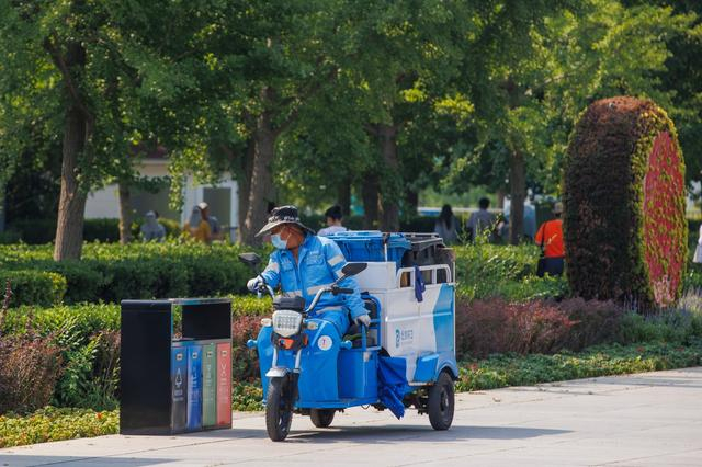 6月23日，北京北中轴线景观大道，保洁人员在烈日下工作。  新京报记者 王子诚 摄