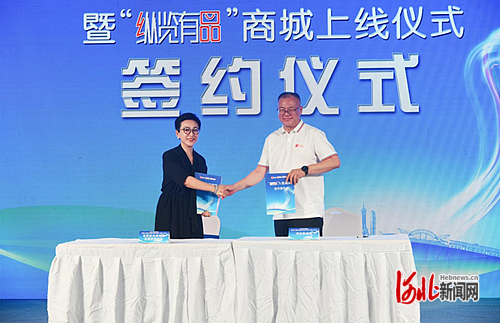 图为首批入驻商城商家代表与“纵览有品”商城进行合作签约。