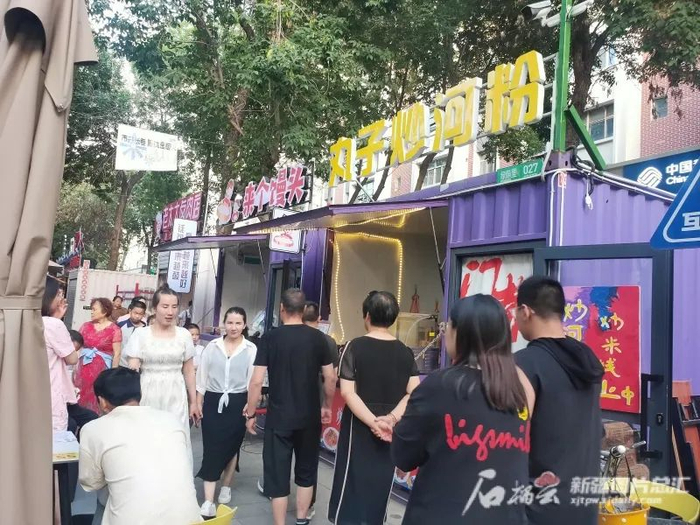 6月30日，在石河子市建设路文化商业步行街，不少游客趁假期和亲友相聚品美食。杨璐铭摄