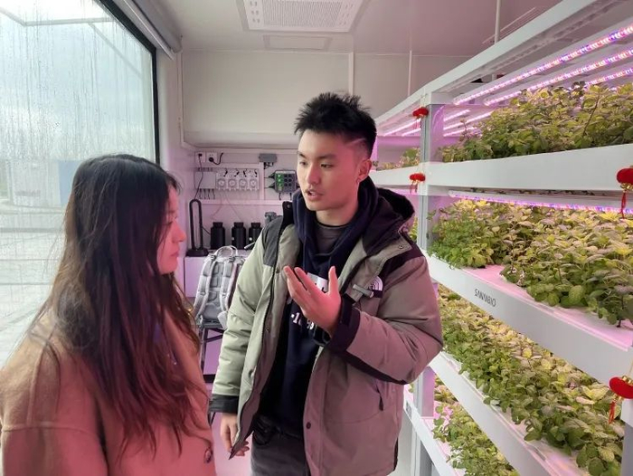 　　熊元科（右一）在植物工厂中讨论生菜种植/受访者供图