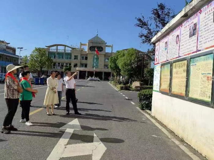 代中、郑露一行来到王化镇好人事迹展示墙前，观看好人事迹展。