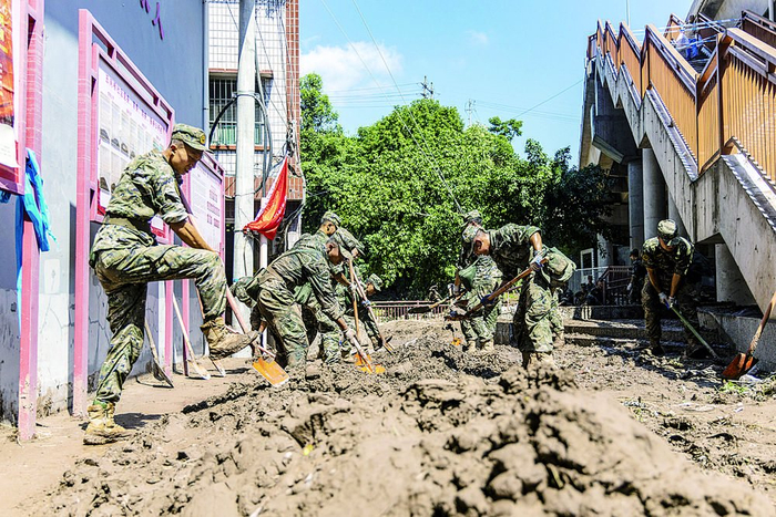     武警官兵忙着清除淤泥