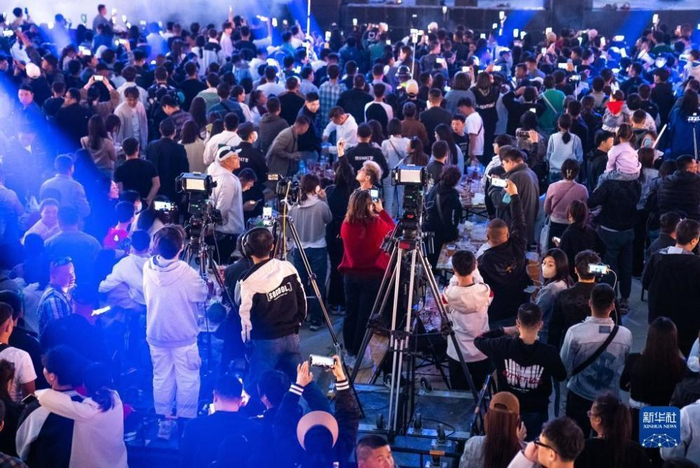 4月29日，在淄博烧烤街，来自全国各地的摄影师在拍摄烧烤节 图片来源：新华社